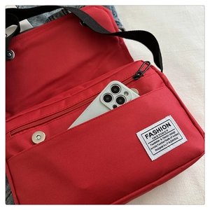 Detailed view of red nylon crossbody bag showing interior capacity with a smartphone inside