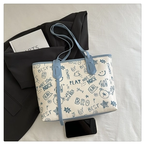Detail of canvas tote bag showing street style graffiti prints and contrast blue trim