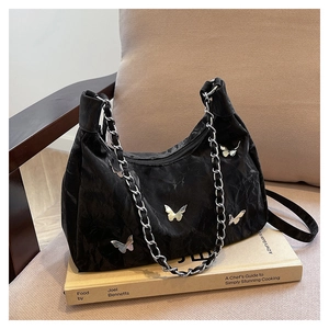 Detail of black hobo bag with marble texture pleats and silver butterfly charms
