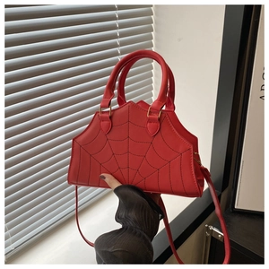 Detail view of red PU leather bag with black spider web stitching and a fine shoulder strap