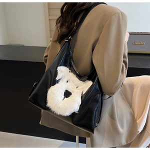 Détail d'un sac cabas en cuir noir avec broderie chien en peluche blanche sur modèle