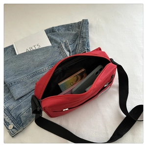 Detail view of red oxford cloth crossbody bag interior with phone and card storage