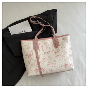 Detail of white tote bag with pink graffiti print and PU leather handles on a white fabric