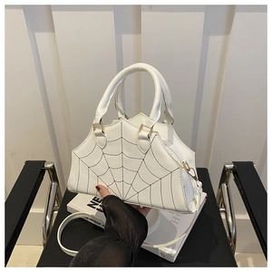 Close-up of spider web embroidery and zipper closure on a white PU leather handbag