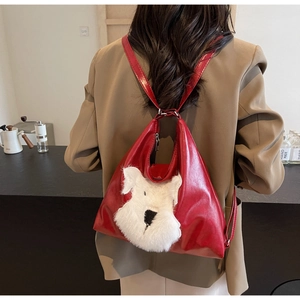 Détail d'un sac à dos rouge en cuir PU avec tête de chiot en peluche blanche