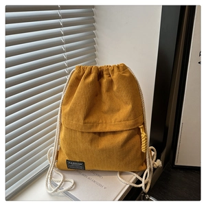 Detailed close-up of yellow corduroy texture and white cotton drawstring straps