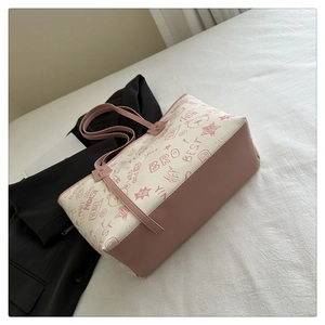 Close-up of pink graffiti bear print and stitching on a synthetic leather tote bag