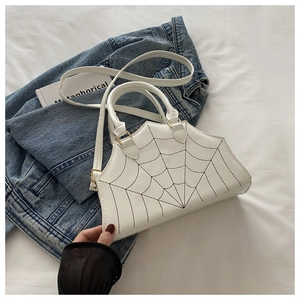 Detail of white spider web bag featuring irregular geometry and golden hardware accents