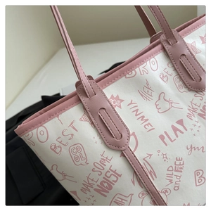 Close-up of pink leather strap and white canvas with graffiti prints on tote bag