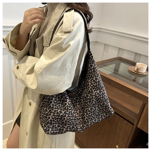 Sac fourre-tout léopard avec lanières en cuir porté avec un trench-coat beige