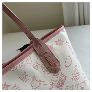 Close-up of pink leather strap stitching and colorful graffiti bear print on tote bag