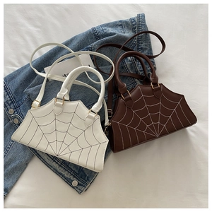 Detailed view of the spider web contrast stitching on white and brown handbags