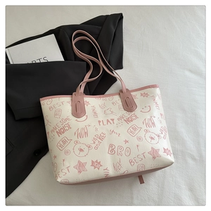 Detailed top view of pink tote bag with cartoon graffiti and stylish shoulder strap