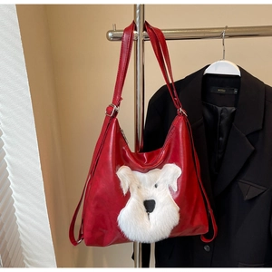 Détail du grand sac cabas rouge avec un patch de chien en peluche blanche et boucles en métal