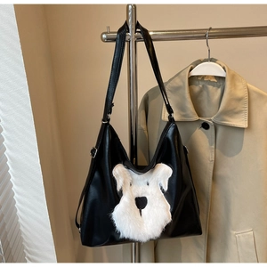 Détail du sac cabas noir avec patch chien en peluche blanc et boucles en métal réglables