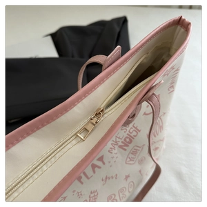 Detail of pink faux leather piping and american graffiti print on cream tote bag