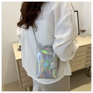 Détail du sac de téléphone argenté holographique avec texture plissée et breloque tressée