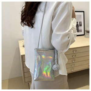 Détail du sac de téléphone holographique argenté avec breloque sphère tissée et lanière