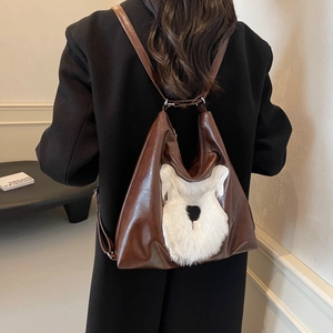 Sac à dos marron en cuir avec patch visage de schnauzer blanc porté par modèle