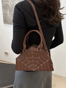 Brown leather crossbody bag with white spider web embroidery and adjustable strap
