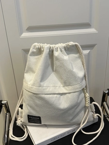 Minimalist beige corduroy drawstring backpack for women featuring texture and woven knots