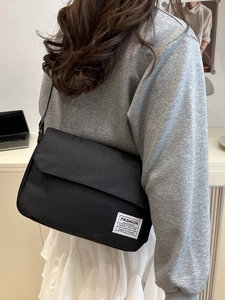 Minimalist black Oxford cloth messenger bag with Fashion Instinct label for men and women