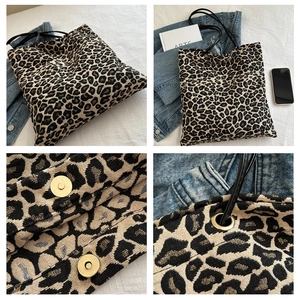 Detailweergave van luipaardprint shopper met metalen oogjes en magnetische sluiting