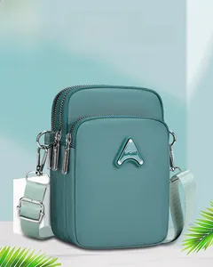 Detailed macro view of the cyan nylon phone bag showing triple zippers and SPORT logo