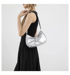 Dettaglio di una borsa hobo argento metallizzato con fiocco decorativo e tracolla sottile