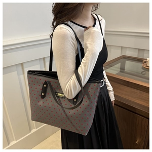 Detail of grey canvas tote bag with red heart pattern and black straps in lifestyle setting