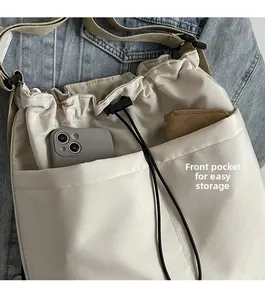 Detail view of water-resistant nylon crossbody bag featuring front pockets for storage