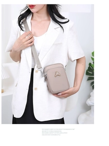 Detail of crossbody phone bag with multi-layer zippers and adjustable wide strap