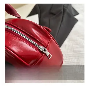 Détail de la fermeture éclair argentée lisse sur un sac à main vintage rouge