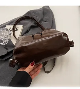 Détail d'un sac seau minimaliste en cuir marron foncé avec cordon de serrage noir