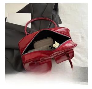 Vue de dessus du sac en cuir ciré rouge montrant l'intérieur spacieux et les objets du quotidien