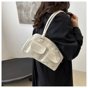 Détail du sac bandoulière Boston blanc crème avec poches à rabat sur manteau noir