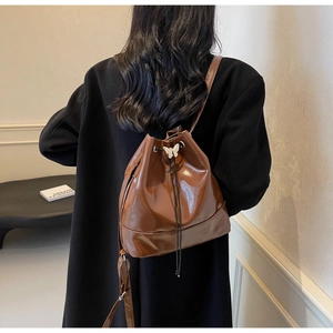 Détail d'un sac à dos vintage en cuir marron brillant avec boucle papillon et cordon