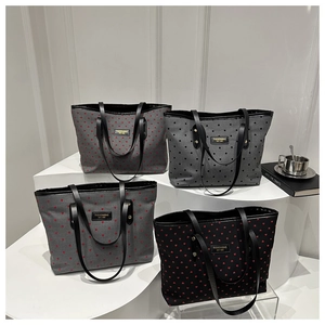 Detail of diverse canvas tote bags with polka dots and heart patterns on a white display