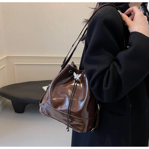 Sac seau brillant marron foncé avec cordon de serrage, breloque papillon et bandoulière fine
