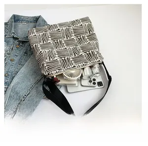 Detail view showing large storage capacity for phone, notebook and cosmetics inside woven bag