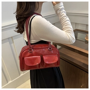 Détail d'un sac à bandoulière rouge brillant vintage avec poches et fermetures argent