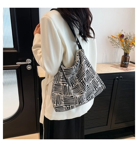 Detailed close-up of a large geometric pattern tote bag with black wide shoulder strap