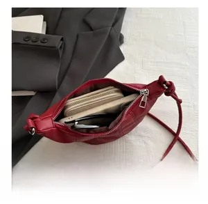 Vue intérieure du sac à bandoulière matelassé rouge foncé montrant l'espace de rangement