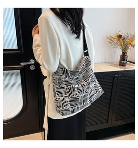 Detail of artistic canvas tote bag with black and white geometric patterns and wide strap