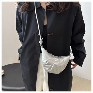 Détail du sac croissant argenté métallisé montrant les coutures et la texture du cuir synthétique