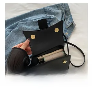 Detail showing the internal capacity of the black leather crossbody bag with magnetic buckles