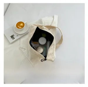 Interior view of cream woven shoulder bag showing spacious capacity for cosmetics