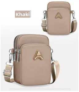Detail view of khaki nylon multi-layer crossbody bags with adjustable straps and sport badge