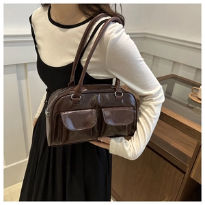 Détail du sac bandoulière en cuir brillant café foncé avec deux poches et boucles argentées