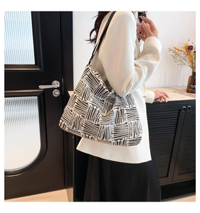 Detail view of large tote bag with black and white abstract patterns on a canvas fabric